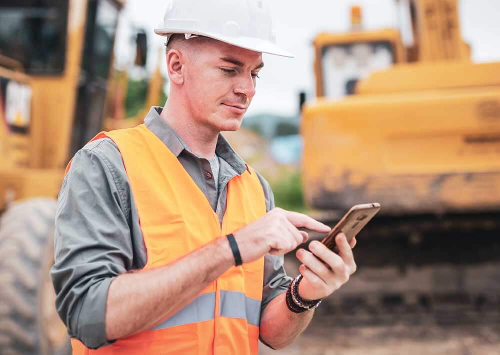 Construction worker using a mobile device and endangering himself and others